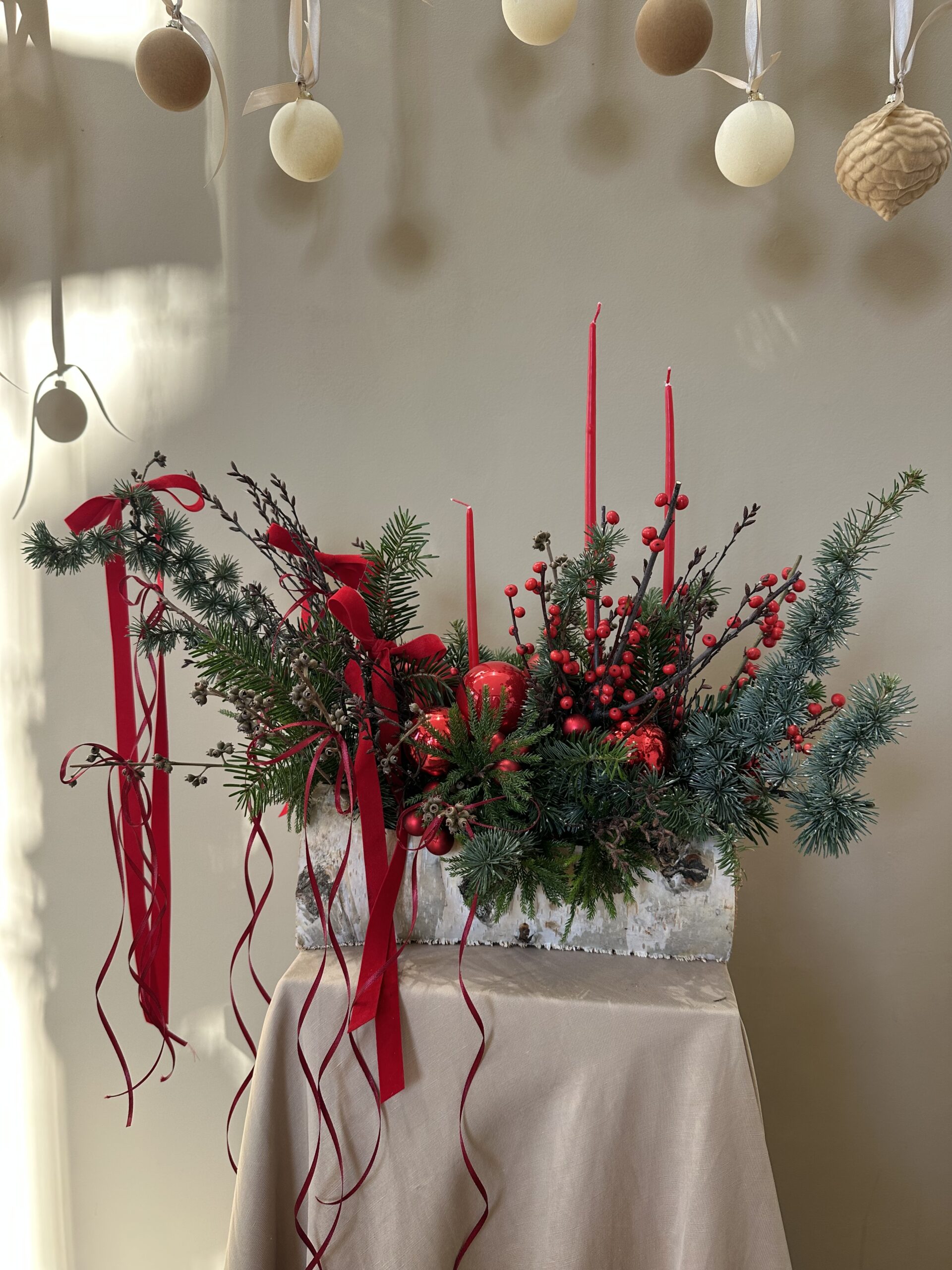 Bûche végétale La Tradition en format moyen, feuillages d’hiver, sapin noble, mousse verte et accessoire monochrome, création Parenthèse Florale Lyon.