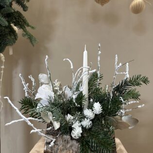 Bûche végétale L’Enneigée, feuillages clairs, mousse poudrée, textures givrées et accessoire monochrome blanc, création Parenthèse Florale Lyon.